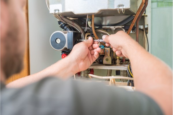 Licensed HVAC contractor installing modern heating system in residential home
